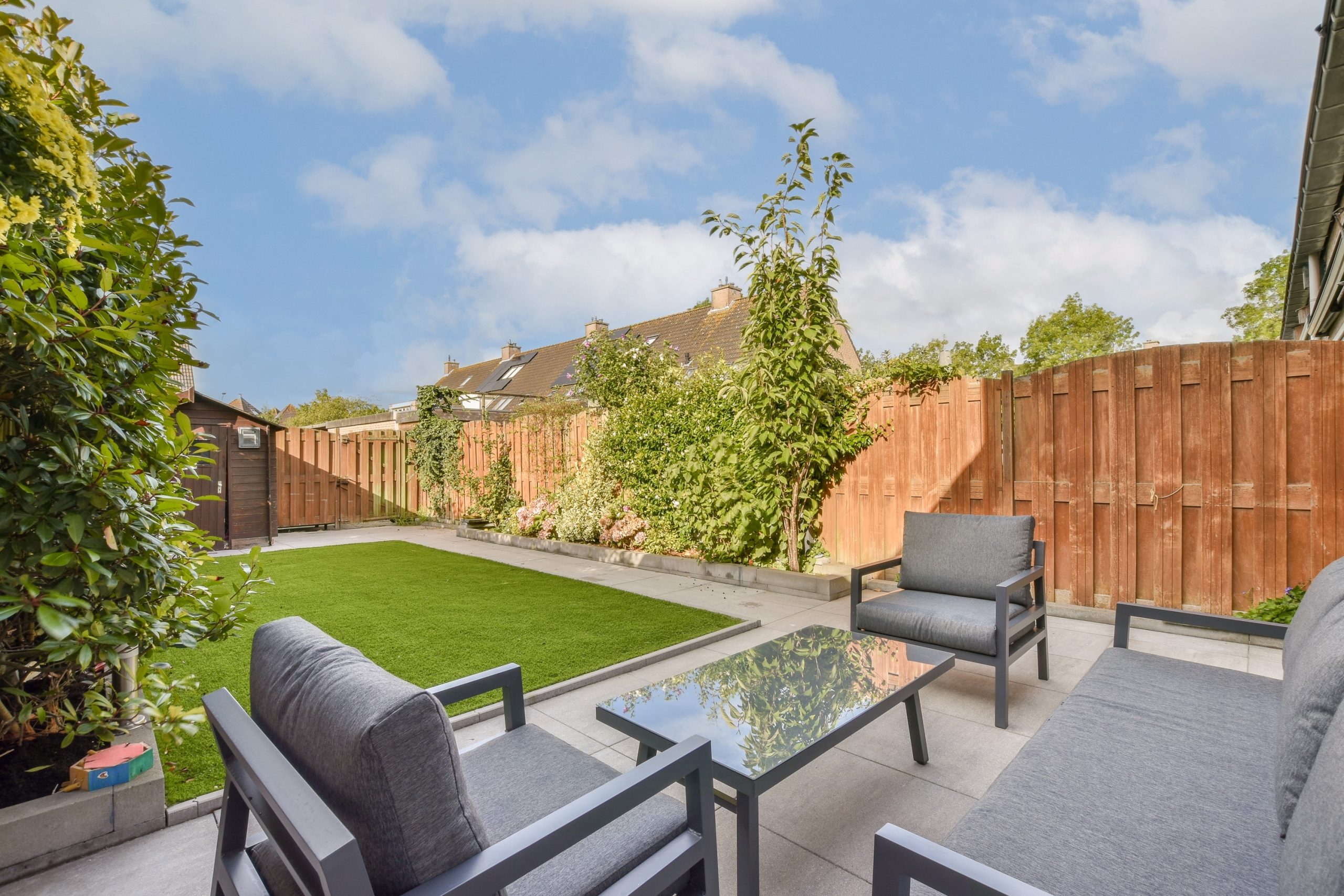 A,Beautiful,Garden,Patio,Showcasing,Modern,Furniture,Against,A,Backdrop